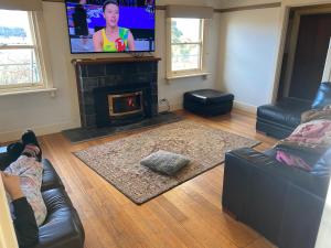 a living room with a fireplace and a tv at 4 bedrooms Relaxing farmhouse getaway in Glenmore 