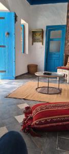 um quarto com uma mesa e uma porta azul em Dar Michèle Djerba em Houmt Souk