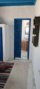 a room with a blue door and a room with a bathroom at Dar Michèle Djerba in Houmt Souk