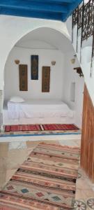 a bedroom with a bed in a room with a rug at Dar Michèle Djerba in Houmt Souk