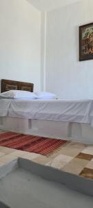 a large white bed sitting in a room at Dar Michèle Djerba in Houmt Souk