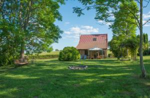 a barn with a red roof in a grassy field at Dom nad jeziorem Granicznym in Stary Żabin