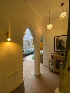 un soggiorno con arco e divano di Riad Dar Adal exclusivité 2 à 6 personnes petit déjeuner compris place jemaa El fna a Marrakech