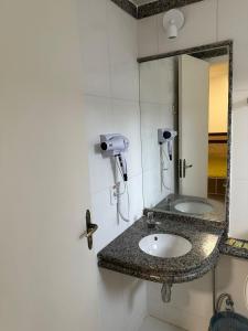 uma casa de banho com um lavatório e um espelho em Diroma Resort em Caldas Novas
