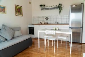 a kitchen with a white table and chairs and a couch at Milena Apartment Opatija in Volosko