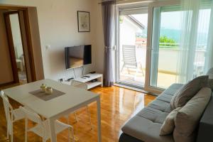 a living room with a couch and a table and a television at Milena Apartment Opatija in Volosko