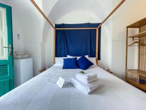 B&B Borgo Monacizzo في Monacizzo: غرفة نوم بسرير أبيض مع وسائد ومناشف زرقاء