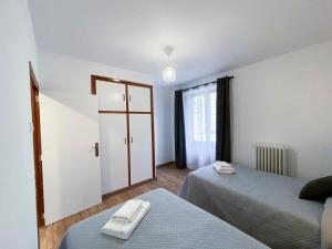 1 dormitorio con 2 camas y puerta con toallas en Apartamento Ara Boltaña, en Boltaña