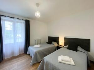 a bedroom with two beds and a window at Apartamento Ara Boltaña in Boltaña