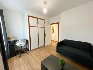a living room with a couch and a desk at Apartamento Ara Boltaña in Boltaña