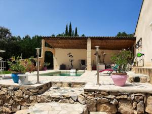 Villa de 2 chambres avec piscine privee jardin clos et wifi a Merindol في Mérindol: حمام سباحة في ساحة مع نباتات الفخار