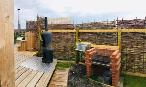 a patio with a brick oven on a deck at Lushna 9 Petite at Lee Wick Farm Cottages & Glamping in Clacton-on-Sea