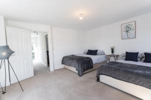 a white bedroom with two beds and a door at April Disc - Long Stay - Contractors in Bristol