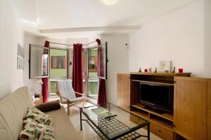 a living room with a couch and a tv at Residencial Sol Suite in Telde