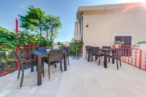 een patio met tafels en stoelen op een balkon bij Villa Popovic in Tivat