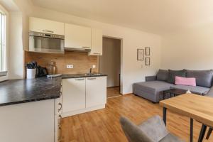 a kitchen and living room with a couch and a table at Kesselgrubs Apartements Ski & Badeglück in Eben im Pongau