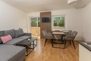ein Wohnzimmer mit einem Sofa und einem Tisch in der Unterkunft Kesselgrubs Apartements Ski & Badeglück in Eben im Pongau