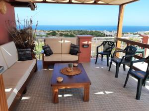 a patio with a couch and chairs and a table at Pensione Casa da AMIZADE B&B in Pedra Badejo