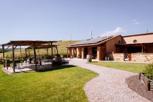 a house with a patio and a grass yard at Agriturismo Giù al Pozzo in Gavorrano