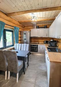 a kitchen with a table and chairs and a sink at Cabana Arsita Poienii in Borsa