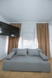 a blue couch in a room with a window at Vila Puky in Neptun