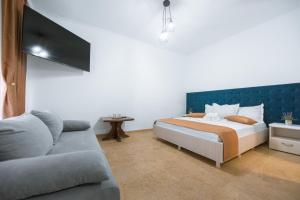 a bedroom with a bed and a couch at Vila Puky in Neptun
