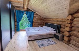 um quarto com uma cama num chalé de madeira em Cabana Arsita Poienii em Borsa