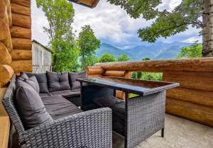 a patio with a couch and a table and chairs at Cabana Arsita Poienii in Borsa