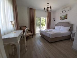 a bedroom with a bed and a desk and a desk at Alaçatı La Vista in Alaçatı