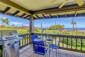 a kitchen with a table and chairs on a balcony at Kaanapali Plantation 54 in Lahaina