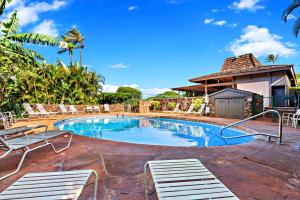 a swimming pool with chairs and a building at Kaanapali Plantation 54 in Lahaina