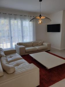 a living room with two couches and a television at Villa Lumie - Superbe villa pour 8 personnes entièrement rénovée en 2023 avec piscine privée in Sainte-Maxime
