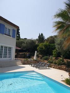 a swimming pool in front of a house at Villa Lumie - Superbe villa pour 8 personnes entièrement rénovée en 2023 avec piscine privée in Sainte-Maxime
