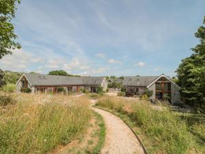 une maison avec un chemin de terre menant à une maison dans l'établissement Shepherd Oak, à Broadwey