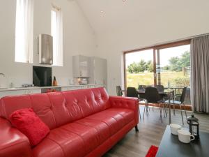 Everdene في Broadwey: أريكة جلدية حمراء في غرفة المعيشة