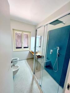 a bathroom with a shower and a toilet and a sink at Piana Apartment in Carloforte