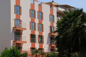 a building with a palm tree in front of it at Terra Aurea Aparthotel in Salou