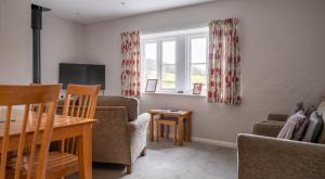 a living room with a table and a tv at Ullswater in Sawrey