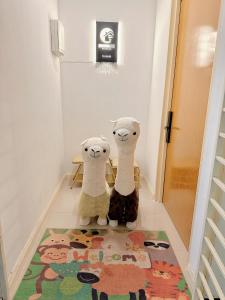 two stuffed animals sitting on a rug in a hallway at MyHomeStay@JB LEGOLAND in Nusajaya