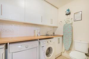 a kitchen with a washing machine and a sink at Beachy Barn in Eastdean