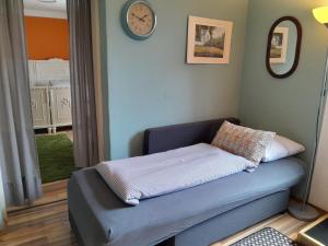 a couch in a room with a clock on the wall at Apartment Süd in Sankt Pölten