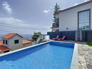 a swimming pool in the backyard of a house at Casa Teixeira by Atlantic Holiday in Estreito da Calheta