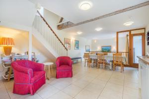 a living room with red chairs and a table at Beachy Barn in Eastdean