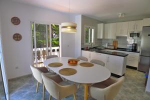 cocina con mesa blanca y sillas en Villa Golondrinas - Private villa to sleep 6, en Nerja