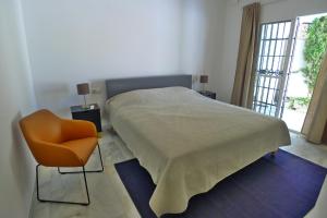 1 dormitorio con 1 cama, 1 silla y 1 ventana en Villa Golondrinas - Private villa to sleep 6, en Nerja