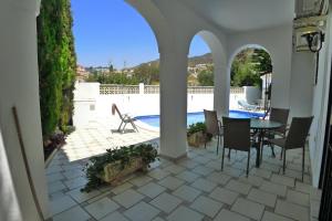 a patio with a table and chairs and a pool at Villa Golondrinas - Private villa to sleep 6 in Nerja