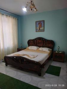 a bedroom with a large bed in a blue room at Adi Doga in Berat