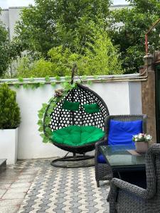 a wicker chair with a green pillow on a patio at Aparthotel Alfa in Ureki