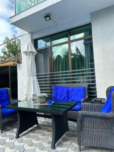a table and chairs on a patio with blue cushions at Aparthotel Alfa in Ureki