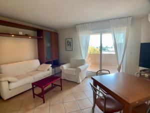 ein Wohnzimmer mit einem Sofa und einem Tisch in der Unterkunft Appartement Hesperides avec Terrasse in Cannes